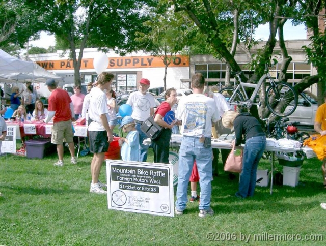 040911NatickDays PART 7 - Events.
Every September since 2001, the Natick Bicycle and Pedestrian Advisory Committee has partnered with other Town committees at Natick Days to publicize the Cochituate Rall Trail and gather new volunteers. Here, a folding mountain bike hoisted high and raffled off.